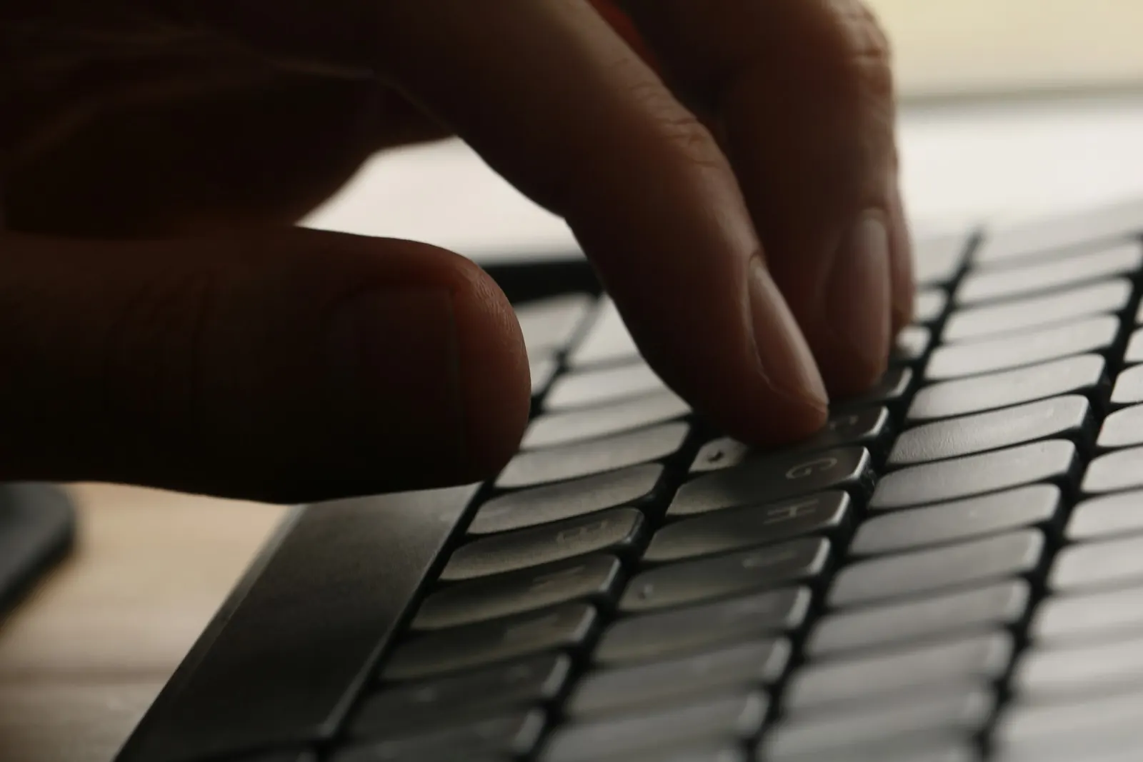 Hands typing on a laptop keyboard